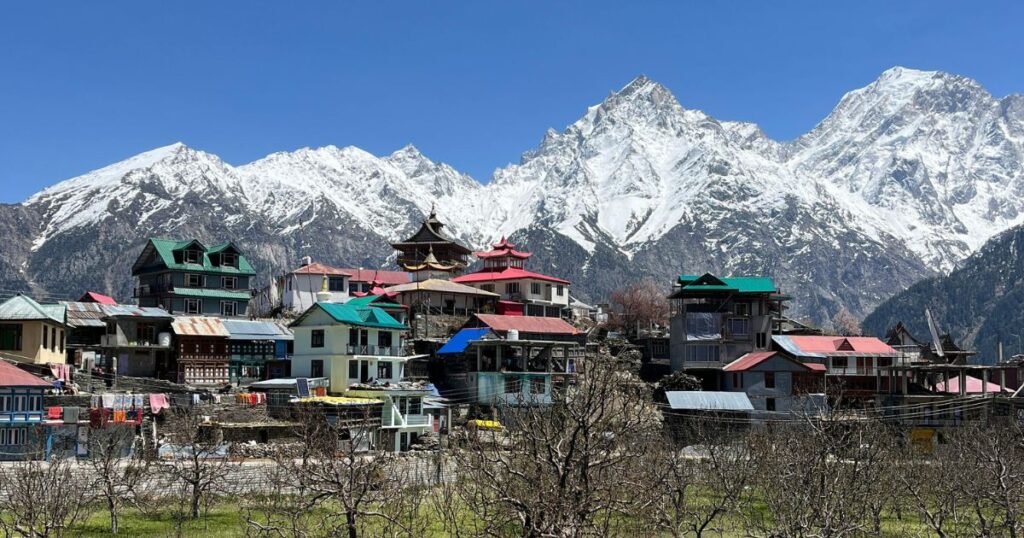 Snow-covered houses in Kalpa with Kinner Kailash in the background.